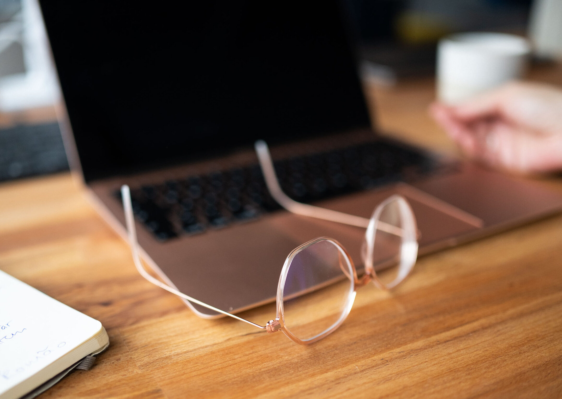 Laptop und Brille auf Schreibtisch